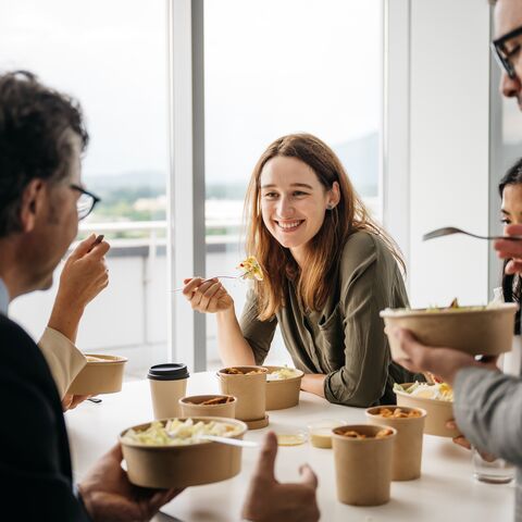 Mitarbeitende nehmen zusammen den Lunch ein.