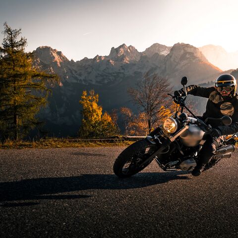 Dans une belle soirée, un motocycliste monte une route de col.