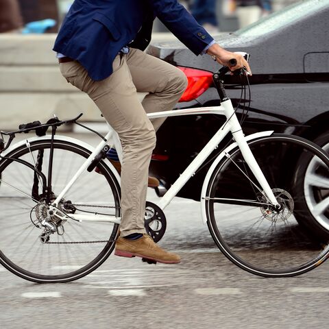 Ein Fahrradfahrer fährt an einer stehenden Kolonne vorbei.