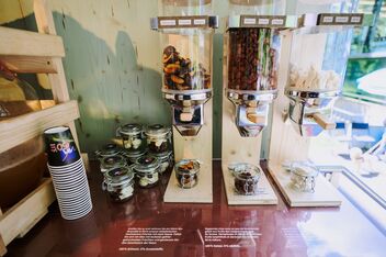 Snack station with dried fruit and apple juice. Next to it a stack of self-service cups.