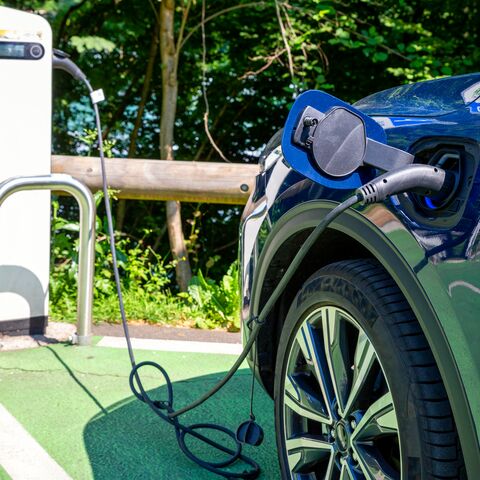 Electric car charging in parking lot at station on sunny day