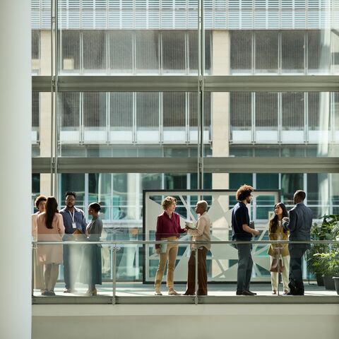 Several people have various conversations in an office building.