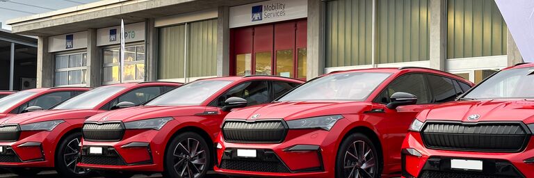 Diverse auto rosse di una flotta di veicoli sono parcheggiate davanti all'edificio del gestore della flotta.