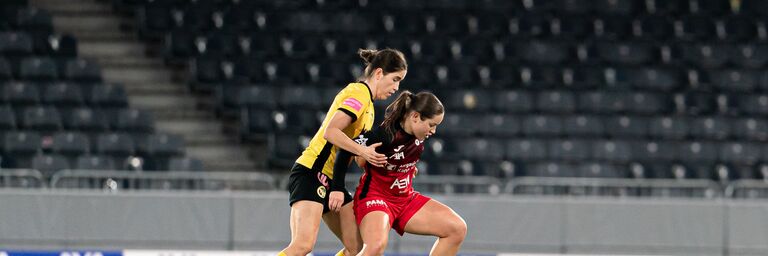 due donne che giocano a calcio in uno stadio
