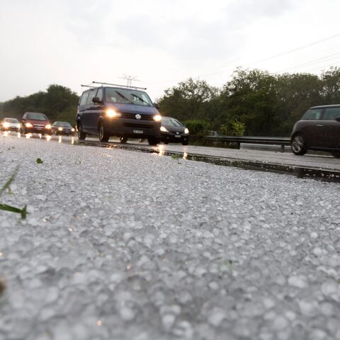 Autobahn nach einem Hagelsturm mit Hagelkörnern auf der Fahrbahn