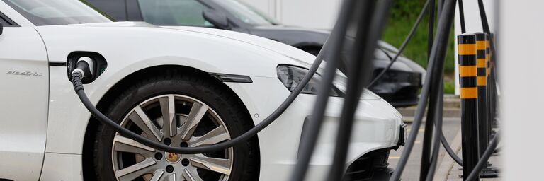Un'auto elettrica è parcheggiata presso una stazione di ricarica.  