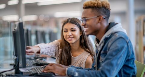 A young apprentice explains something to her colleague on the screen.