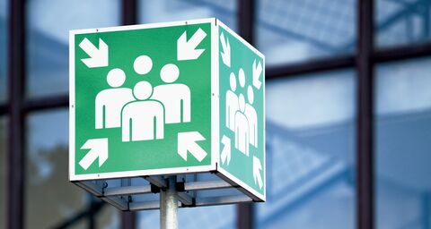 Ein grünes Schild mit dem Signal für einen Notfalltreffpunkt