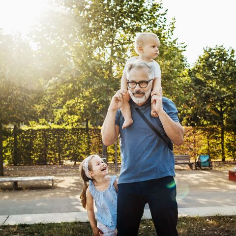 Un grand-père est dehors avec ses deux petits-enfants.