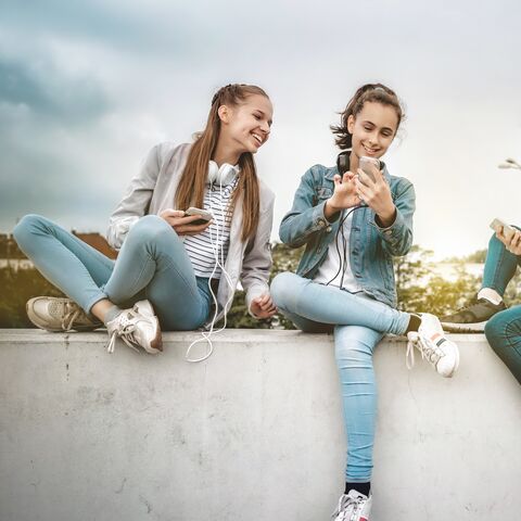 Three women sitting on a wall