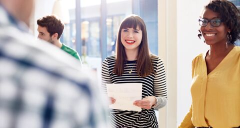 Several employees are chatting animatedly at a workshop.