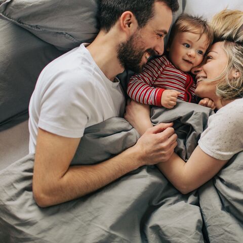 Eltern mit Kind im Bett