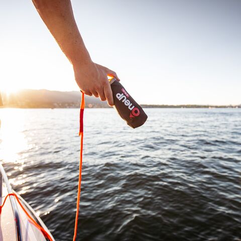 A woman is in the water and needs help. Her girlfriend throws her a new, compact lifebuoy.