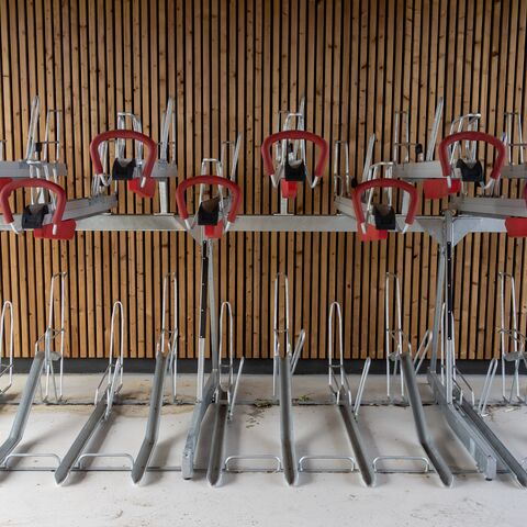 Devant un mur de bois moderne se trouve un porte-vélos vide.