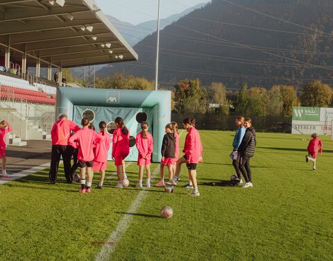 Une équipe est sur la pelouse devant un jeu d’adresse au football organisé par AXA.