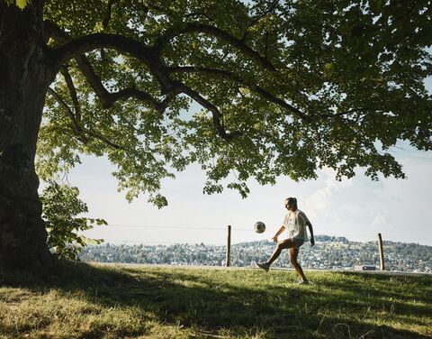 Una donna gioca a calcio in un prato.