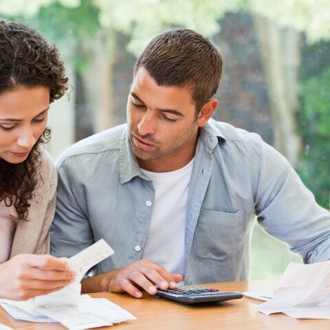 Jeune couple avec des reçus de paiement et une calculatrice