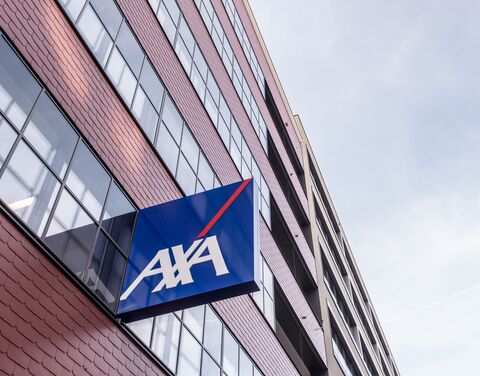 Un moderno edificio ad uso uffici con mattoni rossi e grandi finestre, su cui è visibile un logo AXA blu con scritta bianca e striscia rossa.