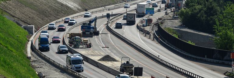 Eine Strasse mit vielen Autos, die fahren. 