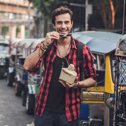 Un ragazzo passeggia per una città asiatica.