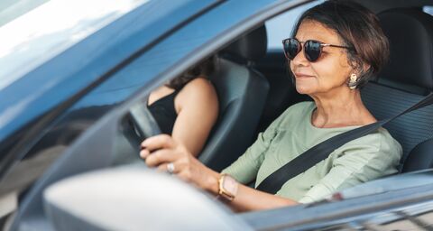 Ältere Autofahrerin mit angelegtem Sicherheitsgurt fährt sicher im Strassenverkehr.