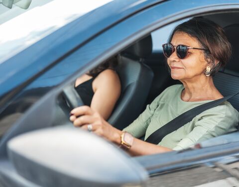 Ältere Autofahrerin mit angelegtem Sicherheitsgurt fährt sicher im Strassenverkehr.