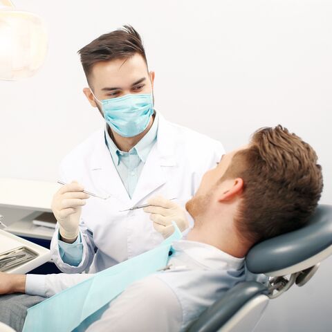 Un jeune homme est chez le dentiste.
