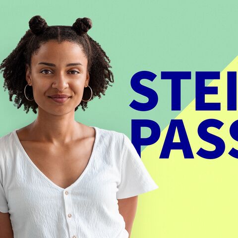 Porträt einer lächelnden Frau mit Afro-Haaren vor einem zweifarbigen Hintergrund mit dem Text "STEIL PASS" in grossen blauen Buchstaben.