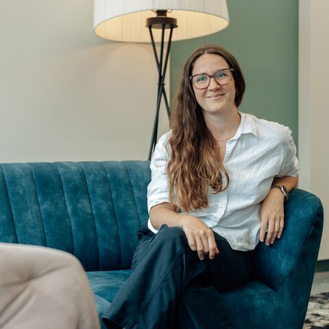 Nora Tombers sitzt auf einem Sofa.