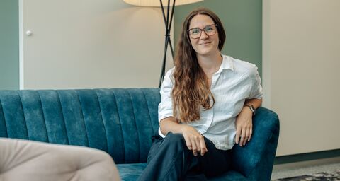Nora Tombers sitzt auf einem Sofa.