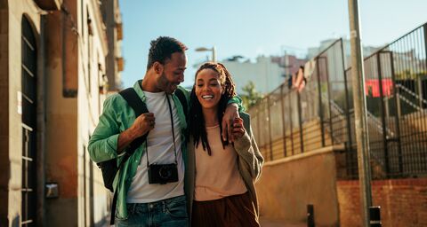 Une femme et un homme sont en vacances et rient tout au long de la route.