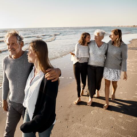 Una famiglia fa una passeggiata sulla spiaggia.