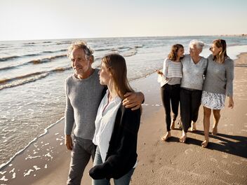 A family is going for a walk on the beach together.