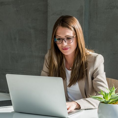Femme d’affaires travaillant sur un ordinateur portable dans un bureau moderne.