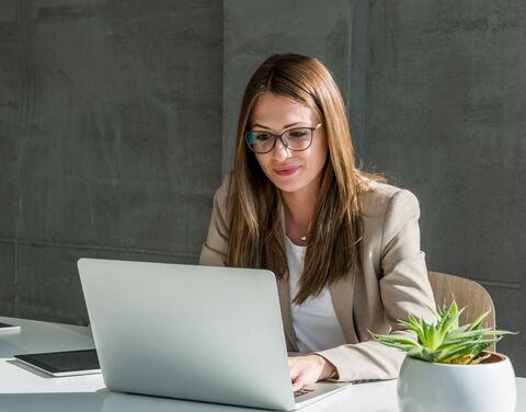 Femme d’affaires travaillant sur un ordinateur portable dans un bureau moderne.