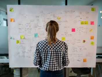 Woman sketching a business plan on a placard at a creative office.