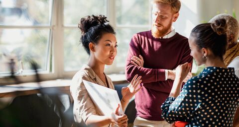 Des collaborateurs et des collaboratrices discutent au bureau.