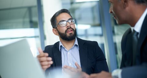 Zwei Mitarbeiter haben ein Gespräch im Büro.