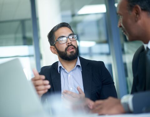 Deux collaborateurs ont une discussion au bureau.