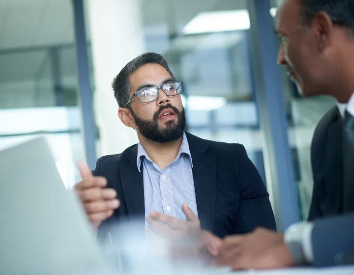Deux collaborateurs ont une discussion au bureau.