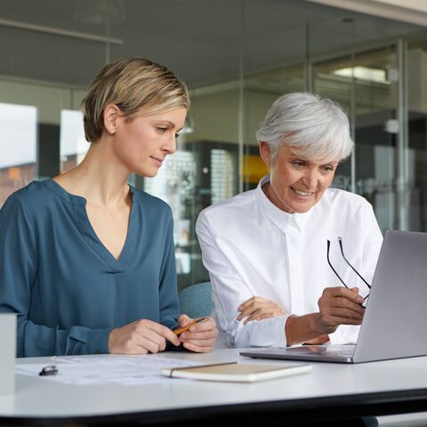Deux femmes travaillant ensemble avec l’ordinateur portable dans le bureau.