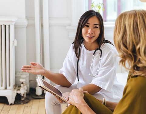 Un médecin s’entretient avec une patiente et lui explique quelque chose sur l’iPad.