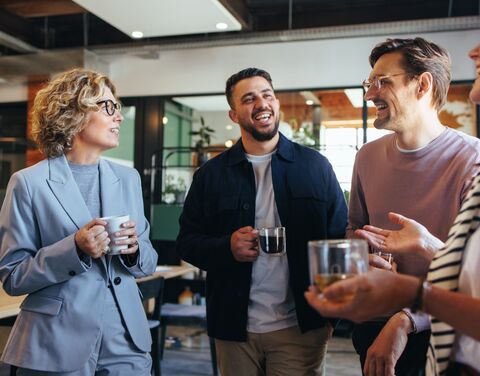 Employees drink coffee together in the office.