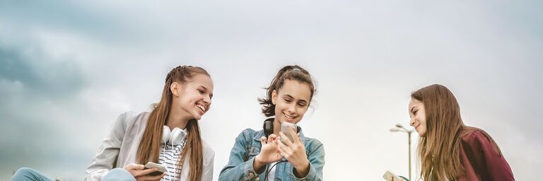 Three women sitting on a wall