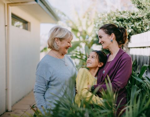 Different generations of women stand together.