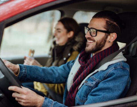 Una giovane coppia viaggia in auto.